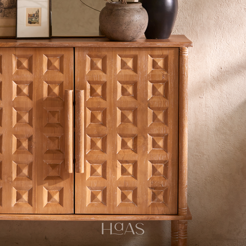 Close-up of the PRABA teak cabinet's carved door panels and handle
