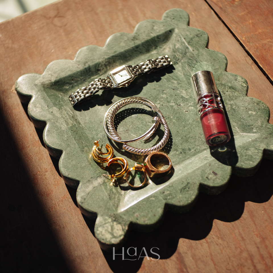 Top view of the OMBAK green marble tray with rings and a lipstick