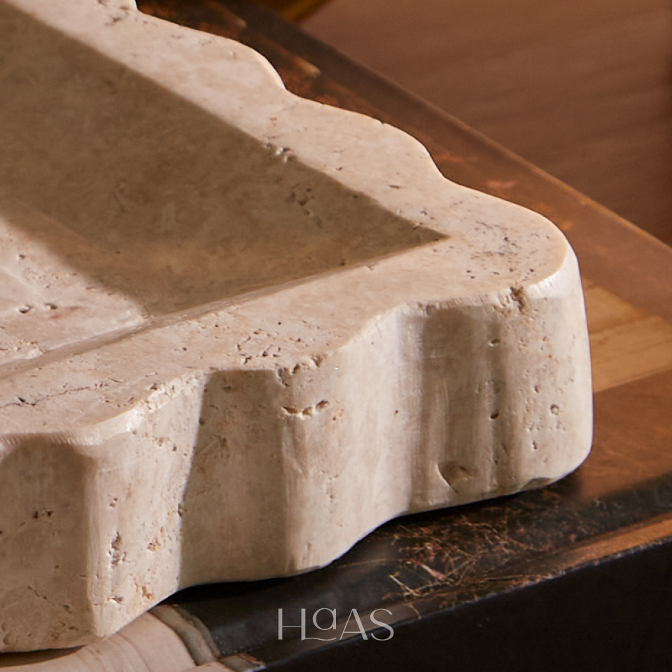 Close-up of the OMBAK tray's carved scalloped edge in natural marble