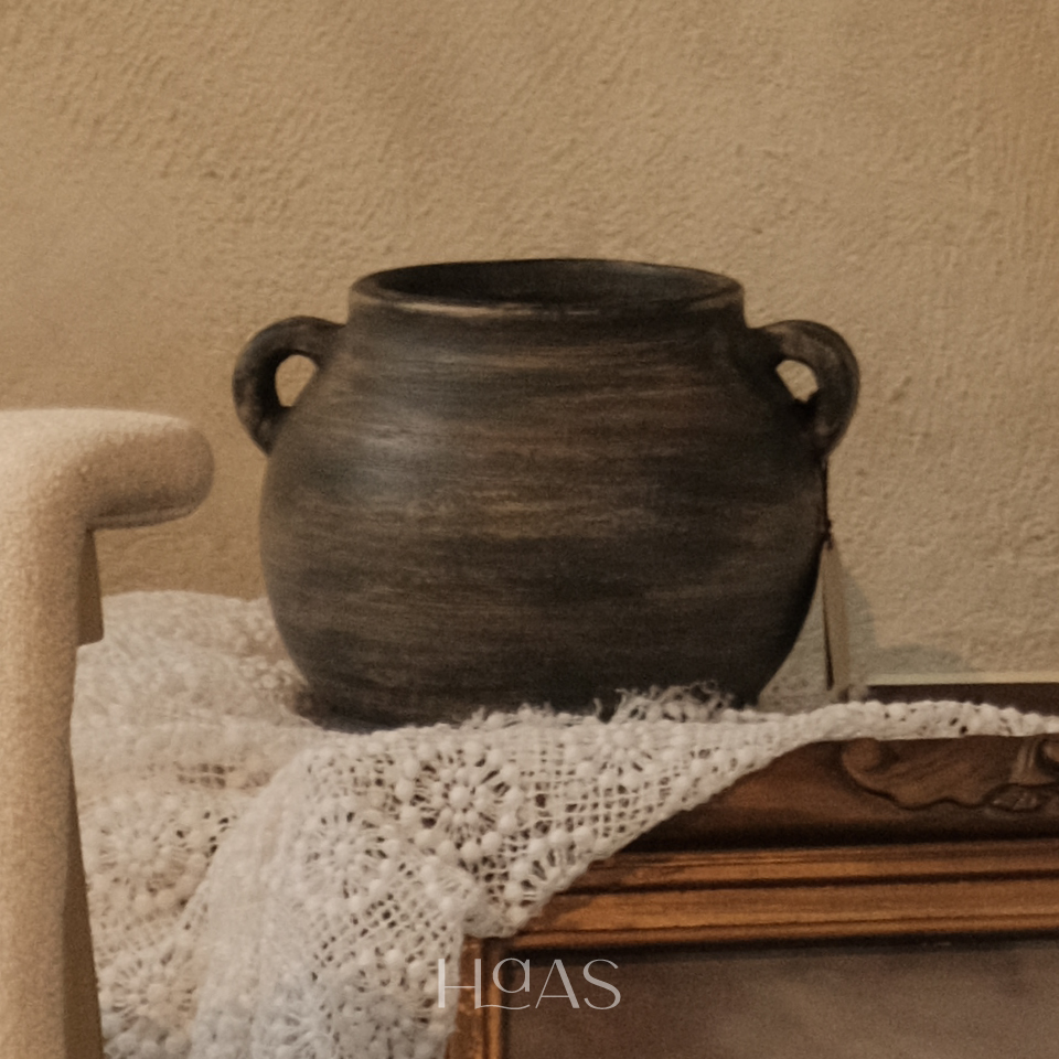 TANO black pottery clay vessel with two handles on a lace-draped console